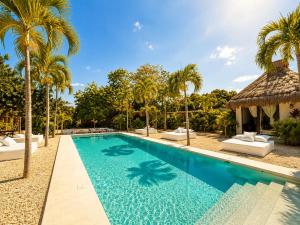 a pool at a resort with palm trees at Villa Luxauthentika Tulum in Tulum +66 photos