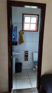 a bathroom with a toilet and a sink and a window at Chalé na floresta com varanda in Ouro Preto