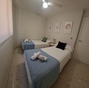 two beds in a room with towels on them at Twin Beach in Torrenueva