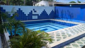 a swimming pool with a blue tiled wall at Casa Finca la Casona con Piscina Privada - Cerca al Parque Tayrona in Santa Marta