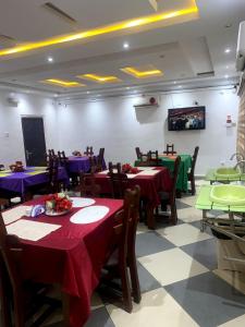 a dining room with tables with purple and green tablecloths at Mambillah Hotel Ikorodu in Ikorodu