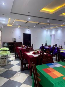 a dining room with tables and chairs with colorful at Mambillah Hotel Ikorodu in Ikorodu