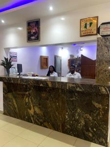 a man and a woman sitting at a bar at Mambillah Hotel Ikorodu in Ikorodu