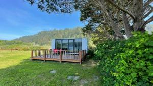 a cabin in a field with a tree at Whistler - Apple Pod in Klamath
