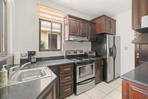 a kitchen with stainless steel appliances and wooden cabinets at Casa Arrecifes in Coco