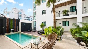 eine Wohnung mit Swimmingpool in einem Gebäude in der Unterkunft Live Coco Suites - Hotel Boutique & Rooftop in Playa del Carmen