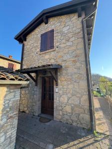 a large stone building with a wooden door at Casina Ghiana in Zocca