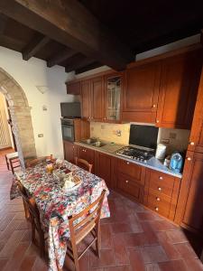 a kitchen with a table with chairs and a kitchen with a stove at Casina Ghiana in Zocca