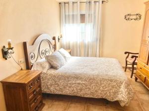 a bedroom with a bed and a dresser and a window at Villa Nadimar - Casa rural con terraza magnífica y 4 habitaciones in Benecid