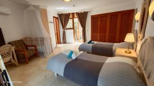 a bedroom with two beds and a couch and a chair at Bungalow 21 Tauro in La Playa de Tauro +79 photos