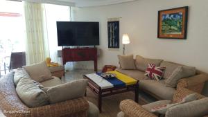 a living room with couches and a flat screen tv at Bungalow 21 Tauro in La Playa de Tauro