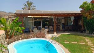 a swimming pool in a yard next to a house at Bungalow 21 Tauro in La Playa de Tauro