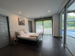 a bedroom with a bed and a large window at Harizou - Chalet & Piscine Intérieure in Saint-Pierre-la-Vieille +16 photos