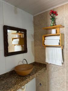 a bathroom with a sink and a mirror and towels at Pousada Wilclé Center Preá in Prea