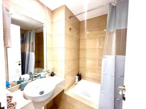 a bathroom with a sink and a mirror and a tub at Royal Breeze Executive Studio in Ras al Khaimah +28 photos