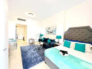 a bedroom with a large bed and a living room at Royal Breeze Executive Studio in Ras al Khaimah