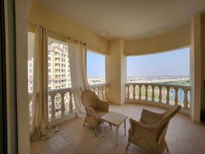 a balcony with chairs and a table and windows at Royal Breeze Executive Studio in Ras al Khaimah