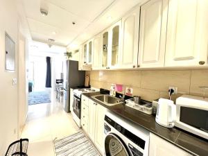 a kitchen with white cabinets and a sink at Royal Breeze Executive Studio in Ras al Khaimah