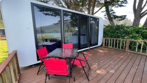 a table and chairs on the deck of a house at Whistler - Apple Pod in Klamath +4 photos