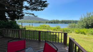 a deck with two chairs and a view of a lake at Whistler - Apple Pod in Klamath