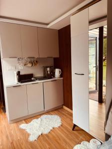 a kitchen with white cabinets and a white rug at Zakątek Młynarza in Pruszkowo +27 photos