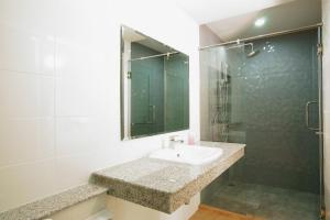 ein Bad mit einem Waschbecken und einer Dusche in der Unterkunft Memory Place Samphran in Sam Phran
