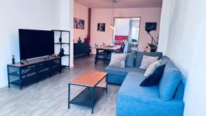 a living room with a blue couch and a table at Le refuge de Boncelles in Seraing