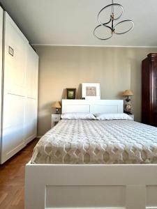 a bedroom with a large white bed with a chandelier at Camera da letto in Angolo di Pace in Grugliasco