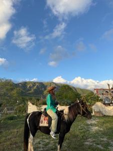 a woman riding a horse in a field at Eagle Park&Camping in Bajkaj