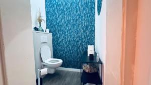 a bathroom with a toilet and a blue wall at Le refuge de Boncelles in Seraing +12 photos