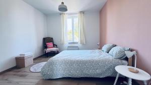 a bedroom with a bed and a table and a window at Le refuge de Boncelles in Seraing