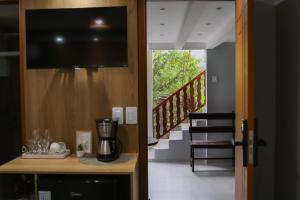 a room with a tv on a wall and a staircase at Casinha de Aldeia in Aldeia Velha