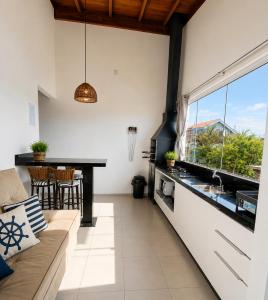 a living room with a couch and a kitchen at Ocean Residence - Aptos Pé na Areia Ponta do Papagaio in Palhoça