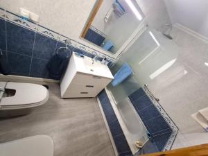 a bathroom with a toilet and a sink and a shower at Dúplex 4 dormitorios Playa Foz in Foz +24 photos