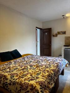 a bedroom with a bed with a floral comforter at Casa Luminara in Guanajuato