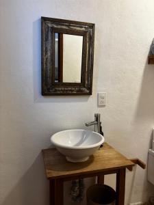 a bathroom with a white sink and a mirror at Casa Luminara in Guanajuato