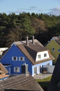 a blue and white house with trees in the background at Ferienhaus Wiekhus in Breege