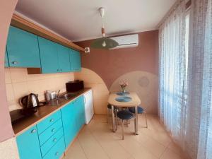 a kitchen with blue cabinets and a small table at DOMEK NR 5 z dwiema sypialniami in Tleń