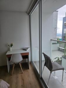 a desk and chair in a room with a window at Cozy studio apartment with a privileged view in Manizales