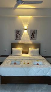 a bedroom with a large bed with two pillows at Malak house swimming pool &Garden in Luxor +60 photos