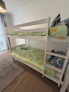 a bedroom with two bunk beds in a room at Captain Normans Sea view in Hollington