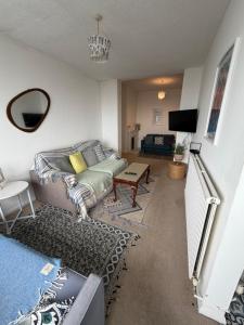a living room with a couch and a table at Captain Normans Sea view in Hollington