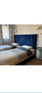 ein Zimmer mit vier Betten mit blauen Kopfteilen in der Unterkunft infinity by Hadil-Rabat centre ville in Rabat