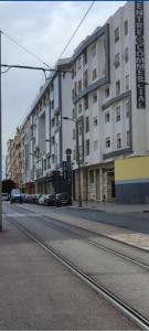 ein großes Gebäude an einer Stadtstraße mit geparkten Autos in der Unterkunft infinity by Hadil-Rabat centre ville in Rabat