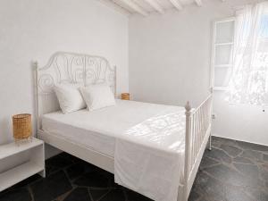 a bedroom with a white bed with a white bedspread at Cozy Summer House in Mikonos +16 photos