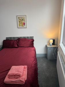 ein Schlafzimmer mit einem roten Bett und einer roten Decke in der Unterkunft PLUS Properties Dike 1 in Stoke on Trent