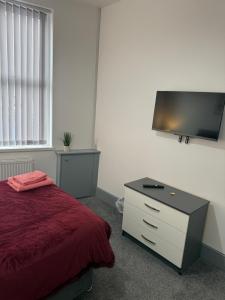 ein Schlafzimmer mit Bett und Flachbildfernseher in der Unterkunft PLUS Properties Dike 1 in Stoke on Trent
