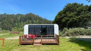 a tiny house sitting in the middle of a field at Blackcomb Apple Pod in Klamath +3 photos