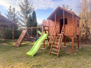 a playground with a slide and a play house at DOMEK NR 5 z dwiema sypialniami in Tleń +2 photos