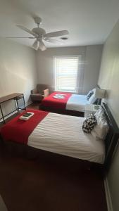 two beds in a bedroom with a ceiling fan at Grand House in Chicago +38 photos